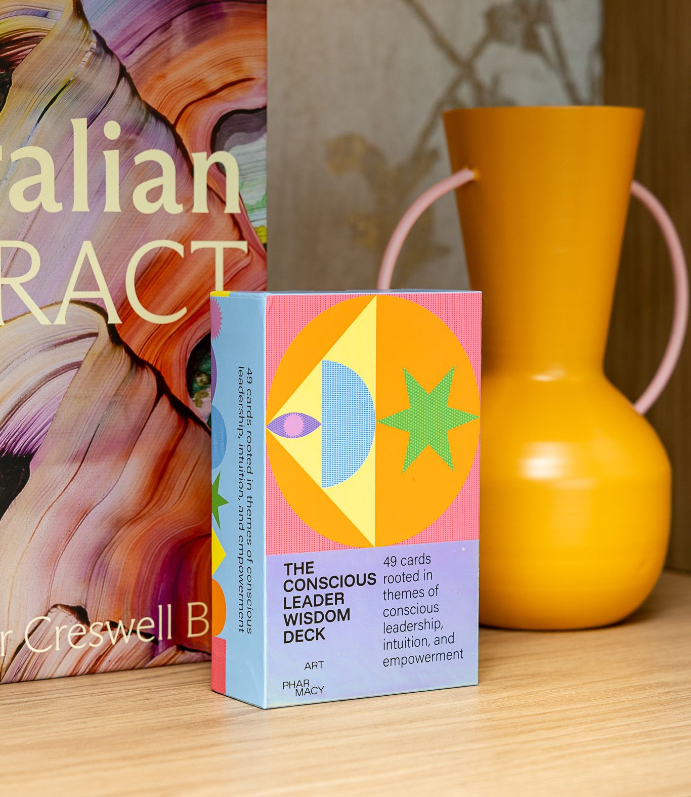 The Conscious Leader Wisdom Deck box on a shelf beside an orange vase